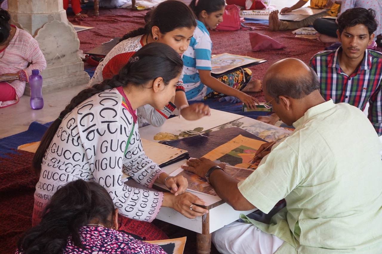 A master teaching traditional Rajasthani style painting inside the Sarvatobhadra Chowk.