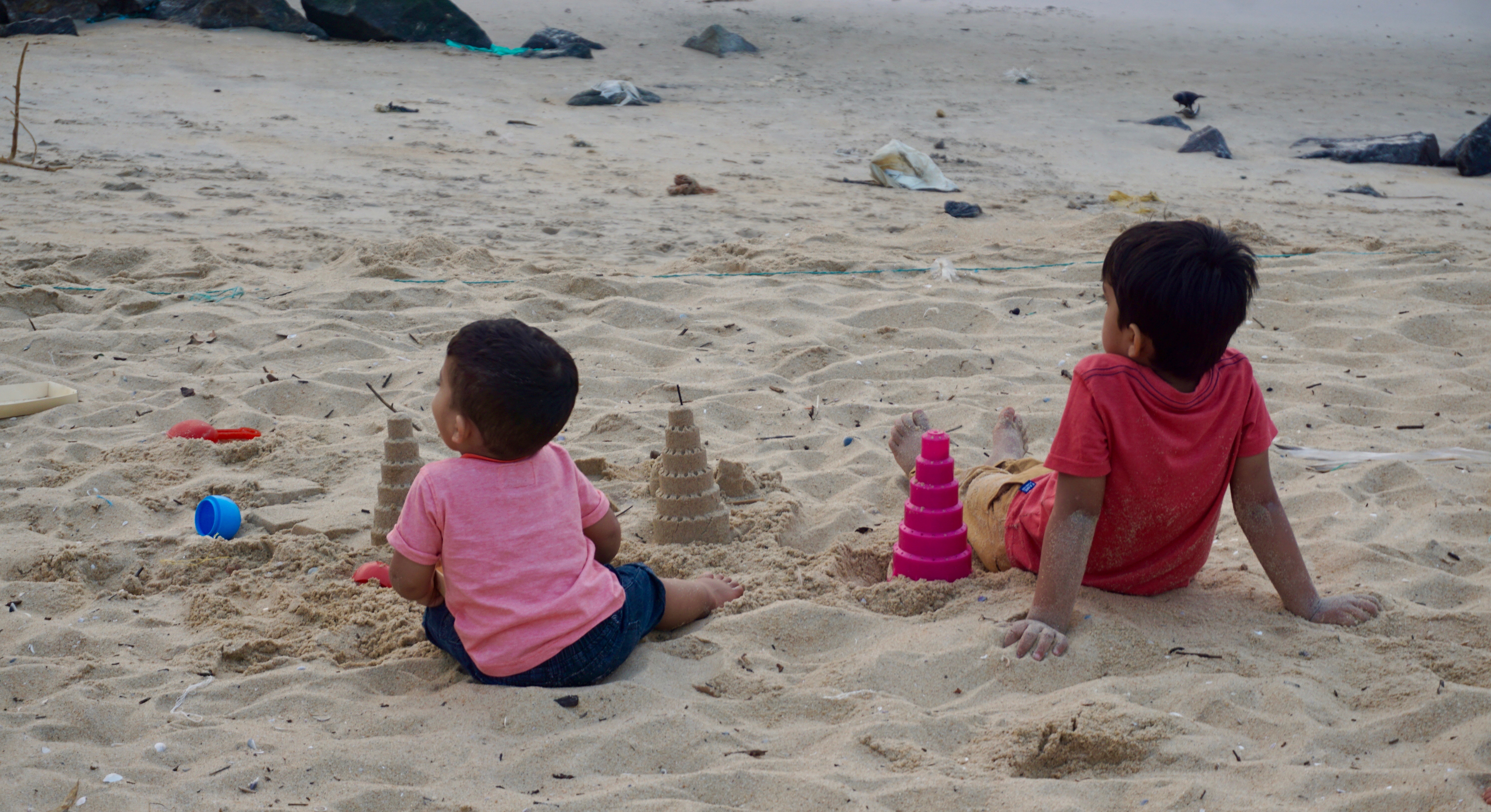 Kids making sandcastles in the sand.