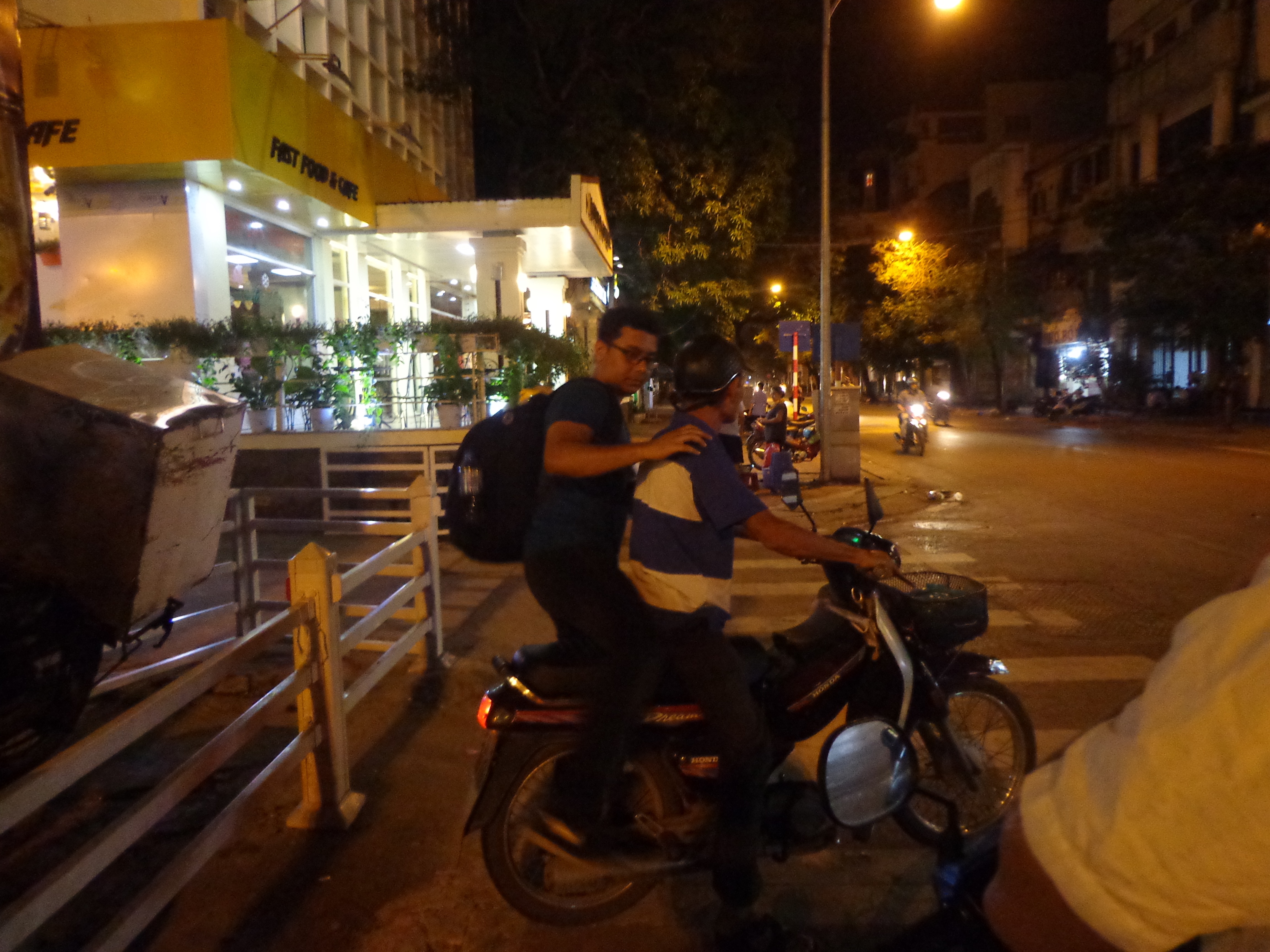 Nandy getting on a hired motorbike as a pillion rider. This mode of commercial transport was a new experience for me (the commercial part, not the transport part).
