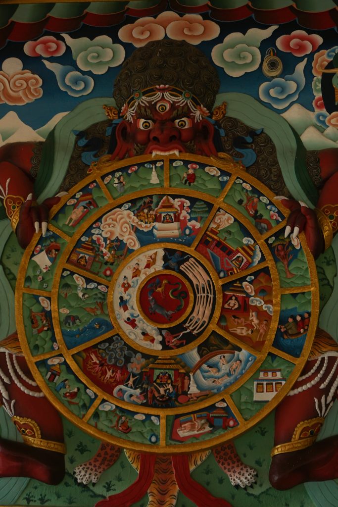 This is how Bhavchakra is usually depicted. This one is at the entrance to the prayer hall. It uses an older depiction with five realms of Samsara. (The god realm and demi-god realm has been depicted as a single realm.)