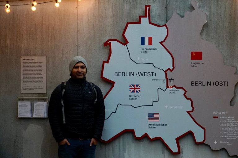 Partho posing in front of a schematic map of divided Berlin. Checkpoint Charlie was a meeting point of borders of all the territories controlled by different allied forces.