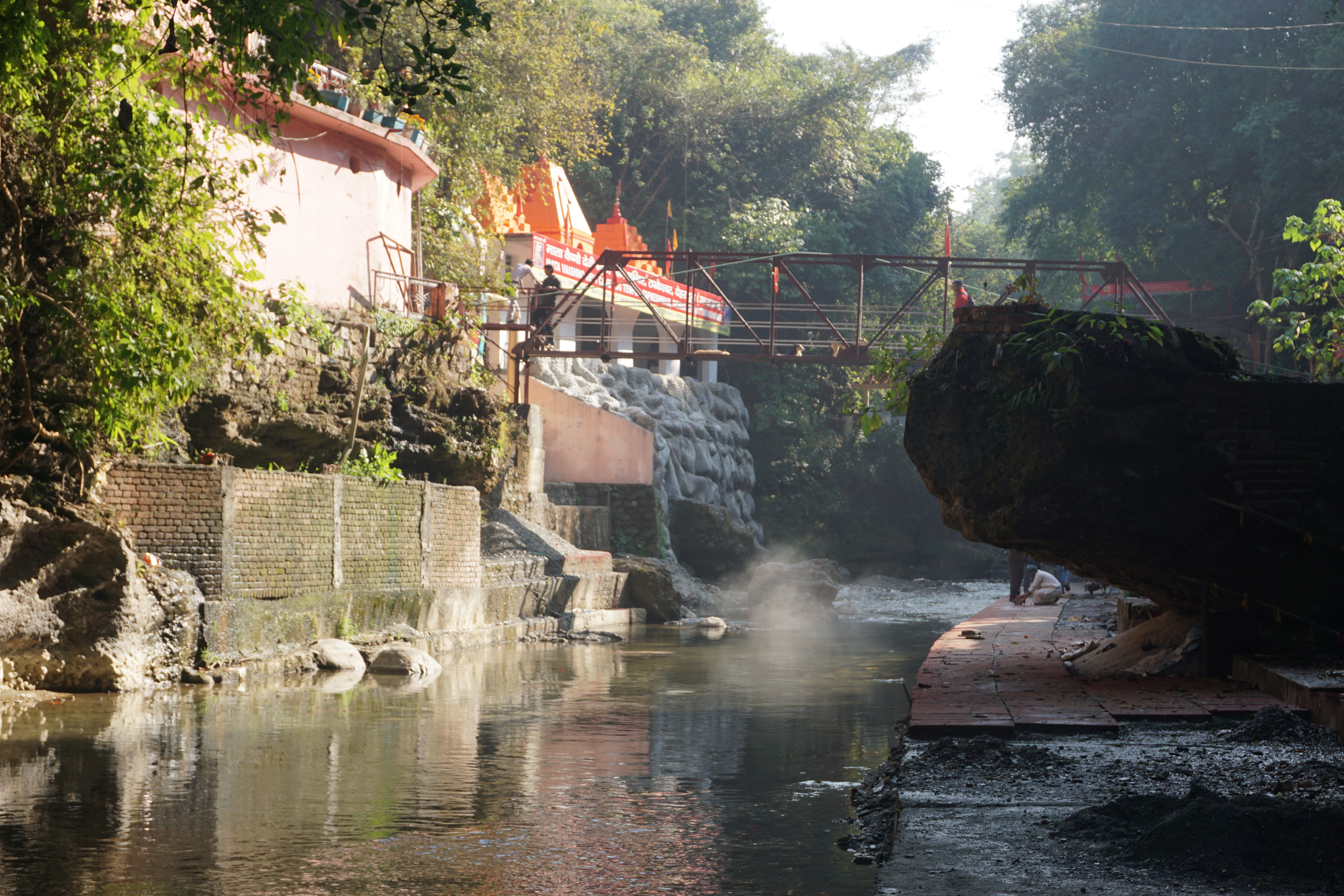 Asan river flowing through the temple complex. Back and right - the cave complex that housed some old and some new idols., with its star attraction being a Shiva face made of seeds of rudraksha. Left visible - temple dedicated to Vaishno devi.