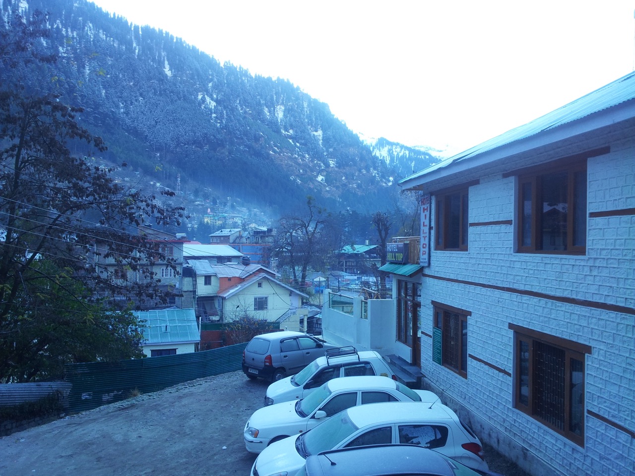 A view from my hotel balcony. A thin layer of snow is visible on the cars&rsquo; windows and windshields.
