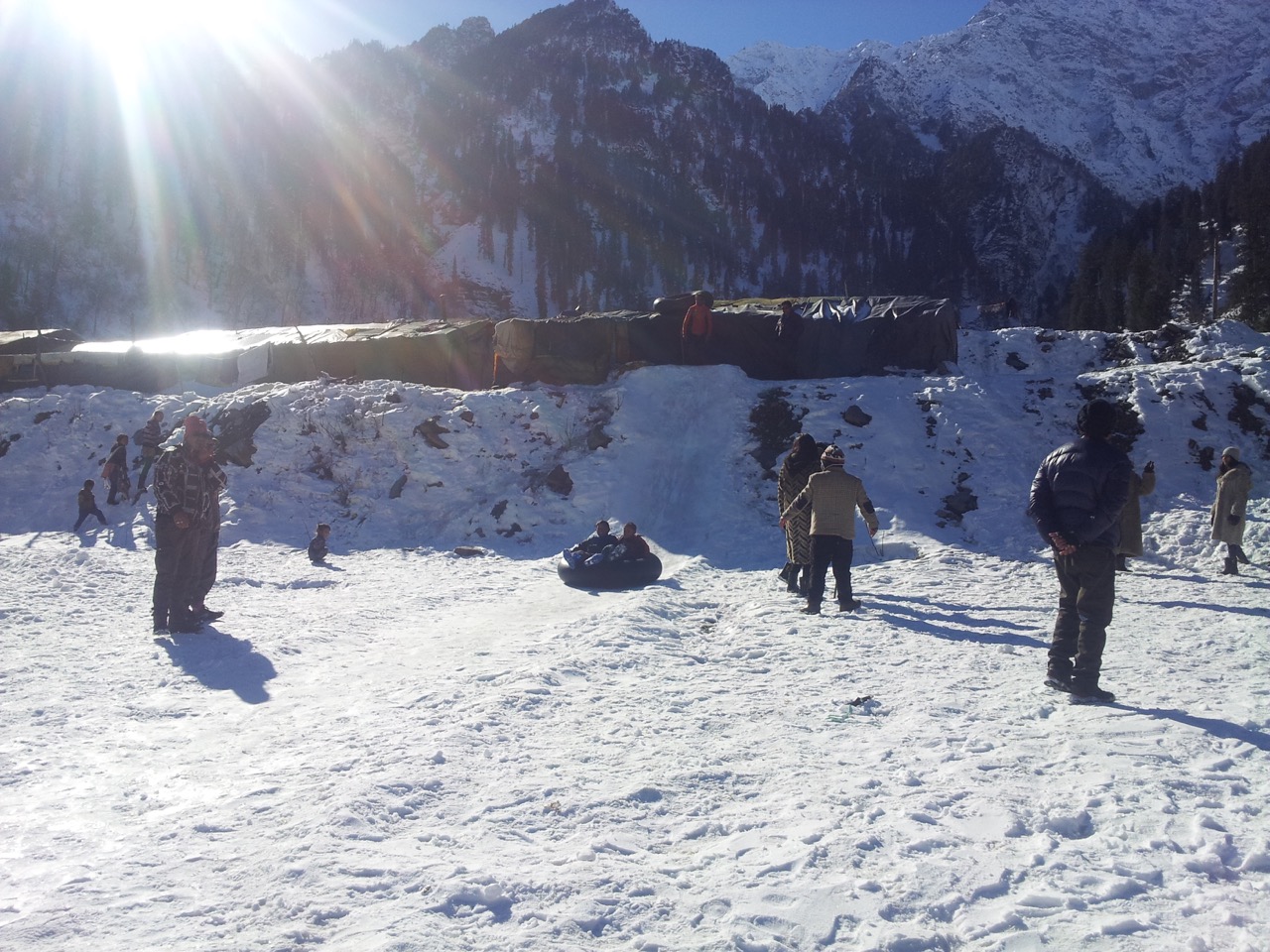 Two kids were playing with an inflated tire.