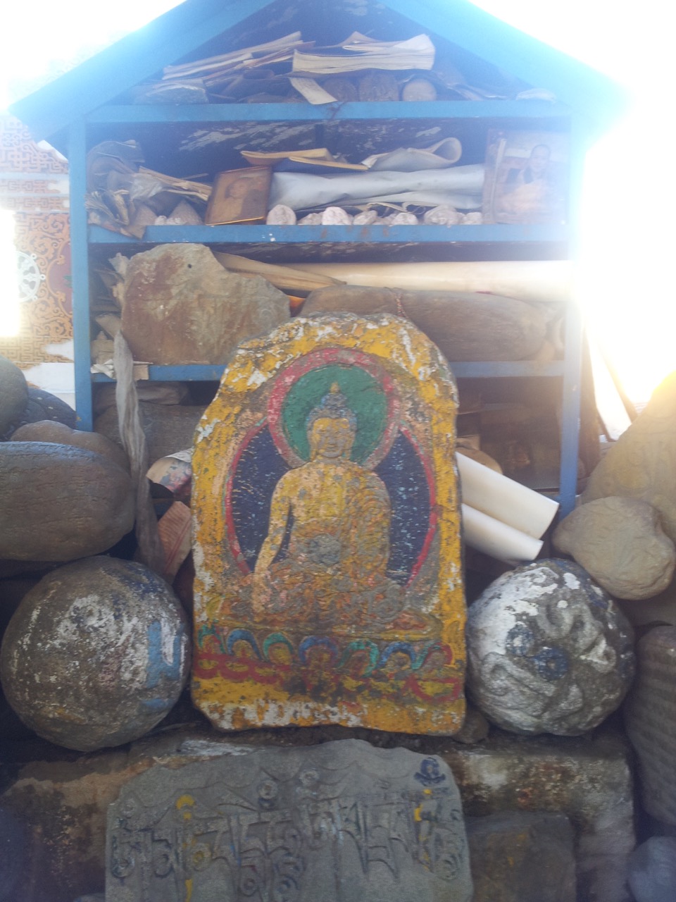 A Buddha idol painted on a stone slab.
