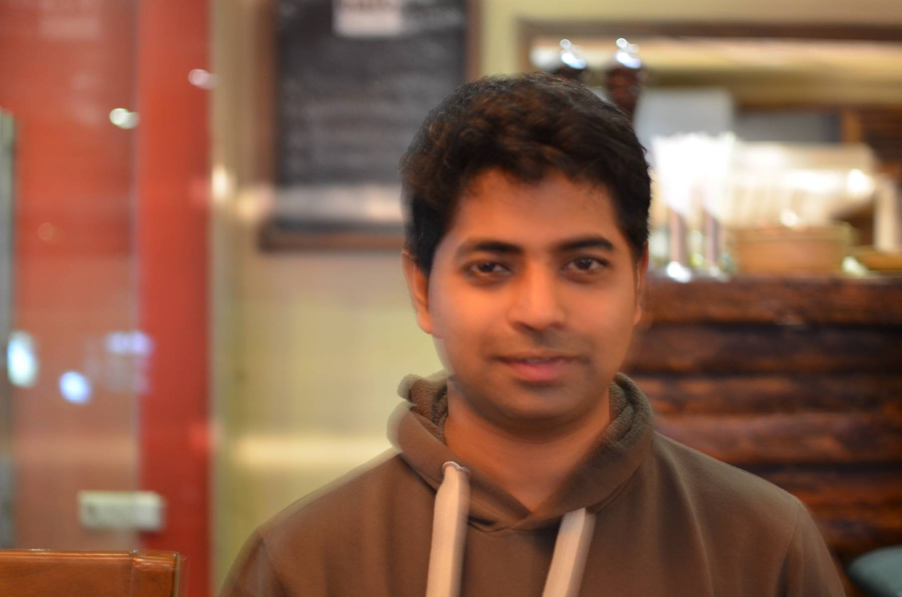 A hazy portrait of me by Nandy. The lighting was really low. Nikon D5100 has a good sensor + processor combo.