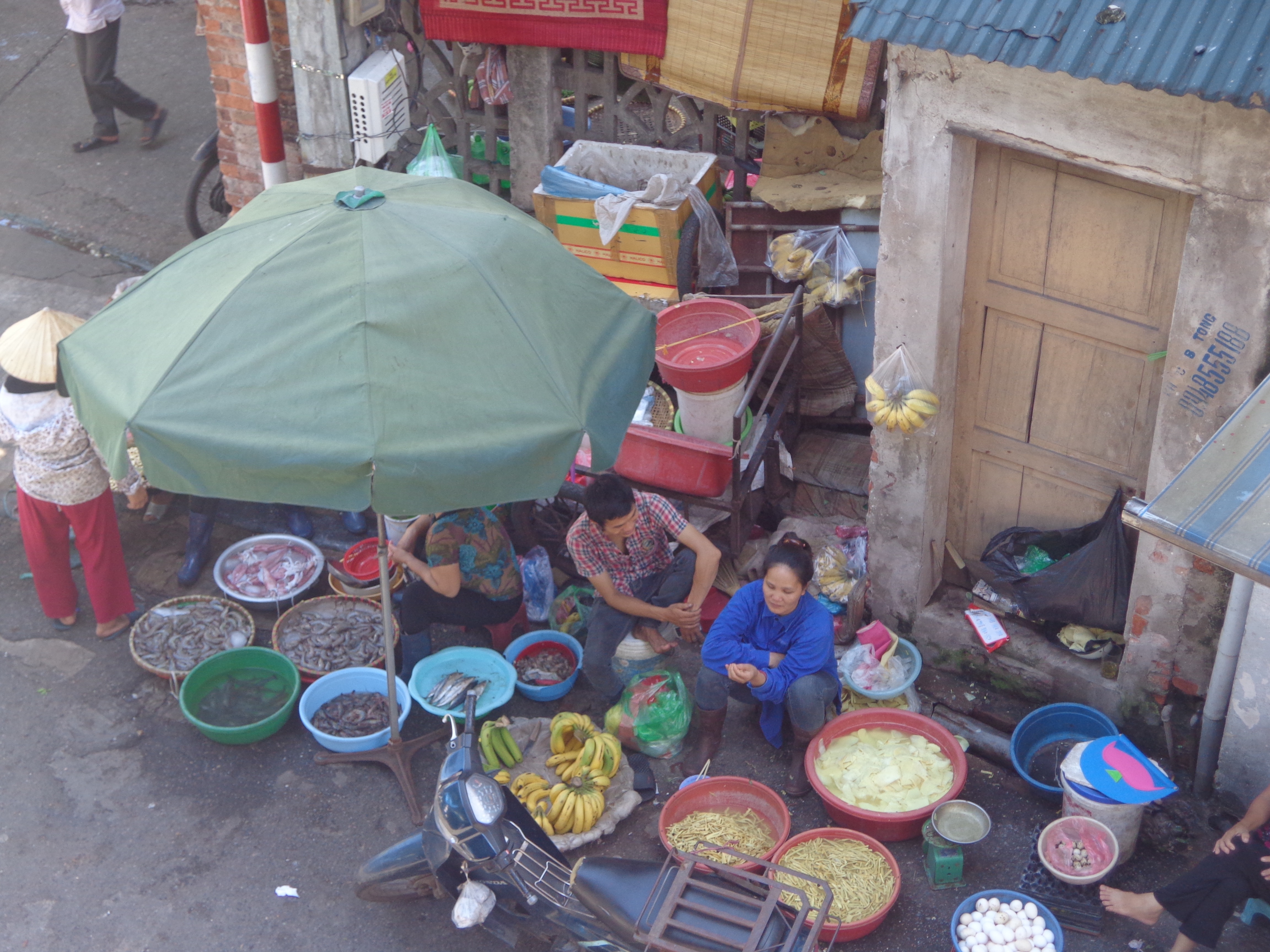 Hawkers sit with fruits, veggies, meat. etc. in the morning on roads of Old Quarter.