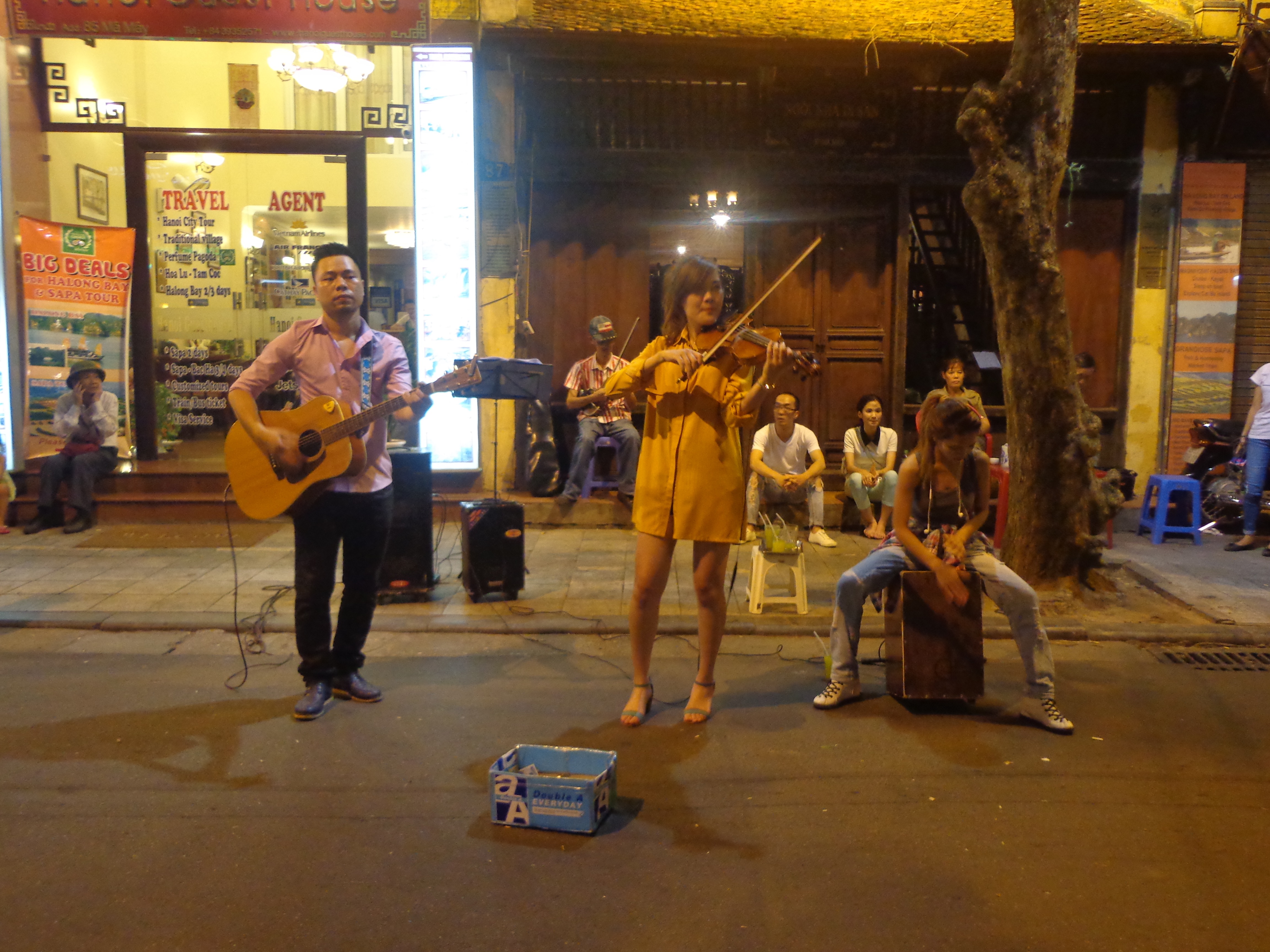 A trio playing Guitar, violin and cajon. An old man was waiting for his performance with a violin.