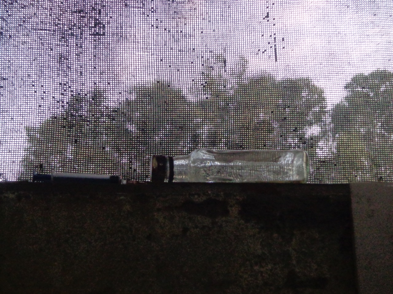 A syringe and the empty bottle on the bathroom ventilator of the waiting room.