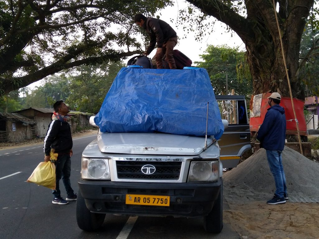 Kumar loading luggage of a passenger from a village outside Tezpur on the Sumo.