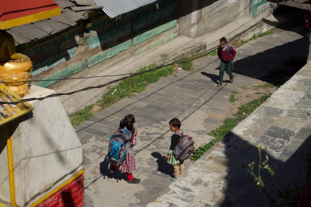 Kids were getting ready to go to school. Almost all of them rotated the prayer wheels located below the Buddha statue.