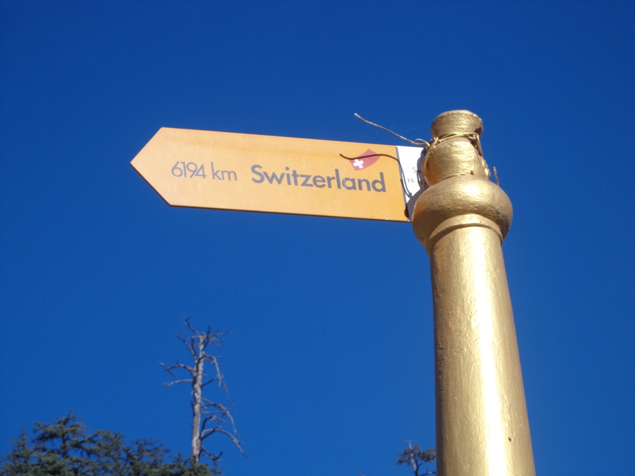 A pole says that the real Switzerland is 6194 kms away.