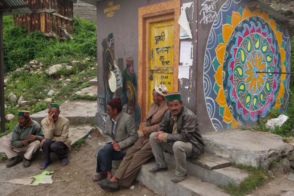 Villagers chatting up near the priest&rsquo;s bath-house. The Wanderer&rsquo;s Nest—a hotel in Chitkul—has painted murals over many walls in the village.