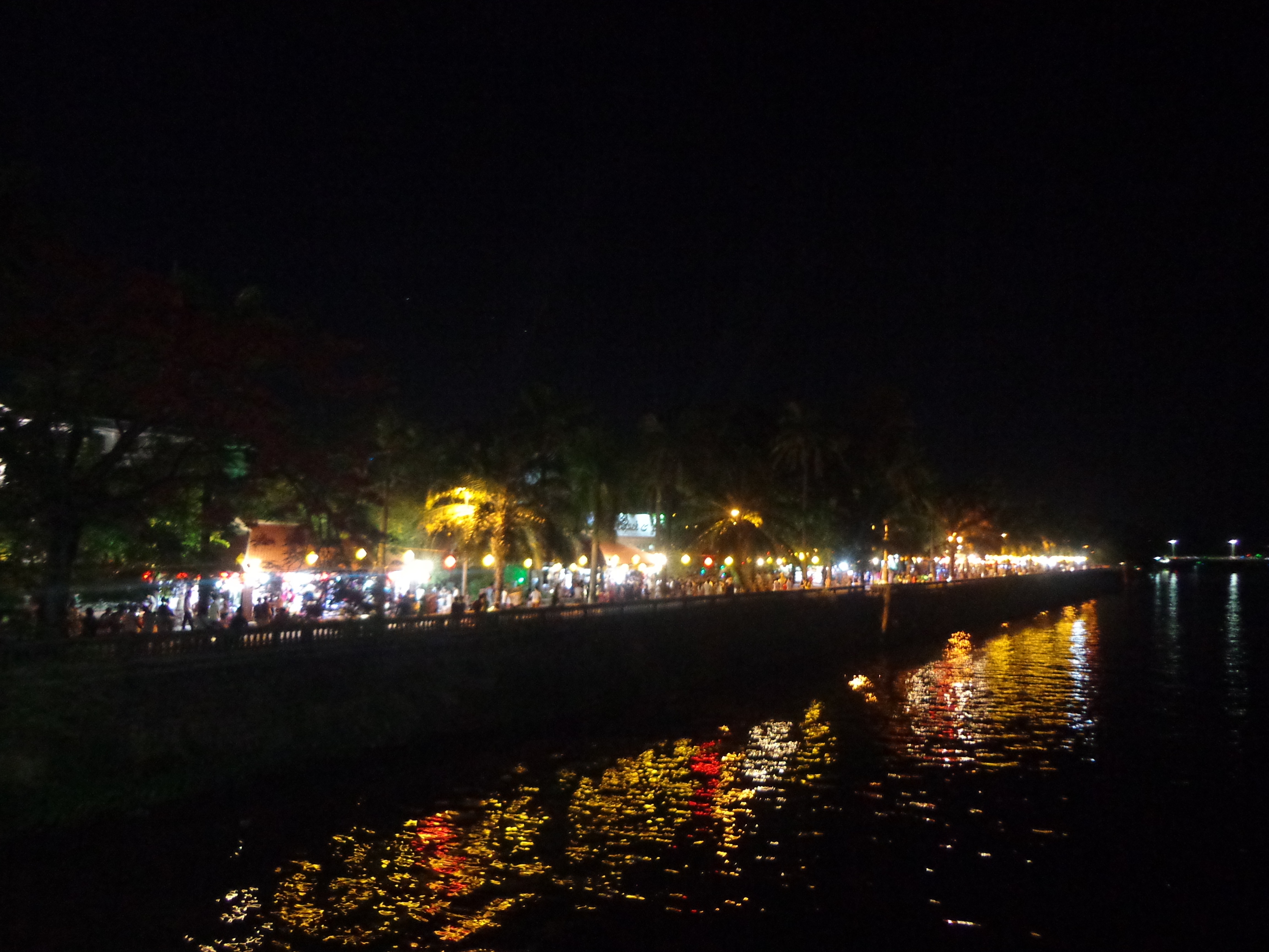 Perfume river at night illuminated by commercial establishments across the river.