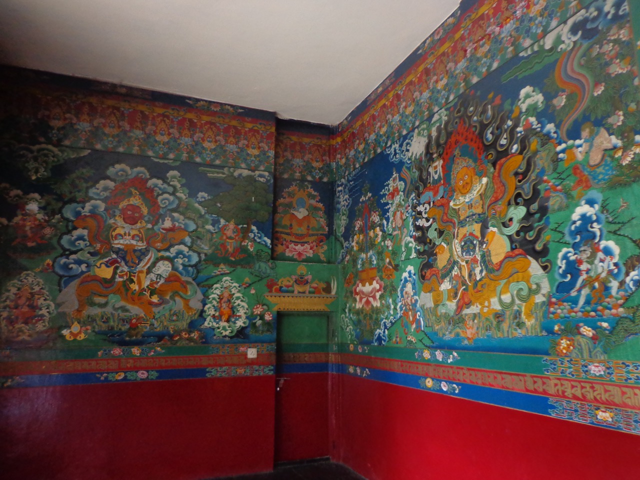 The walls are decorated with traditional Tibetan paintings.