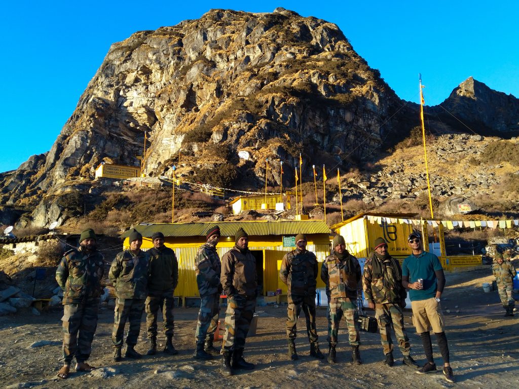 Jawans posing in front of the Gurdwara. The Gurudwara itself is nestled in a cave inside the hill behind them.