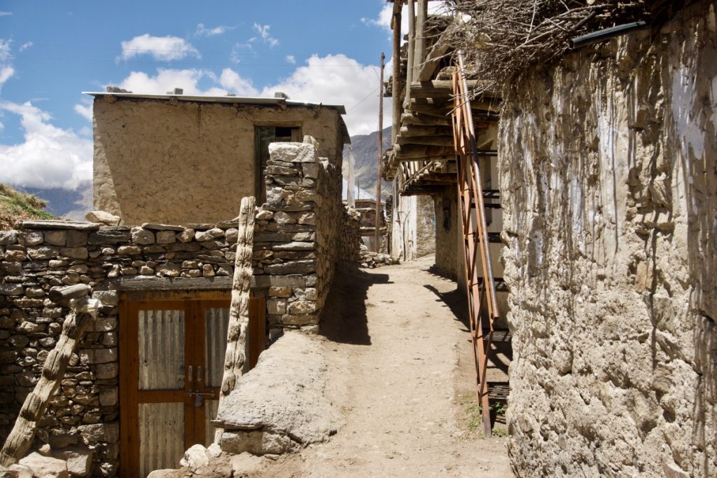 Traditional houses made of mud, stone and wood. The house on the right is a two-storey one. Notice the entrance of the house on the left. There is a latch indicating that no one is in the house but no lock.
