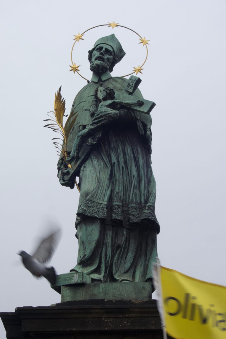 Statue of John, the Nepomunk. This is the oldest statue. He was thrown from the bridge. People touched the base for good luck.