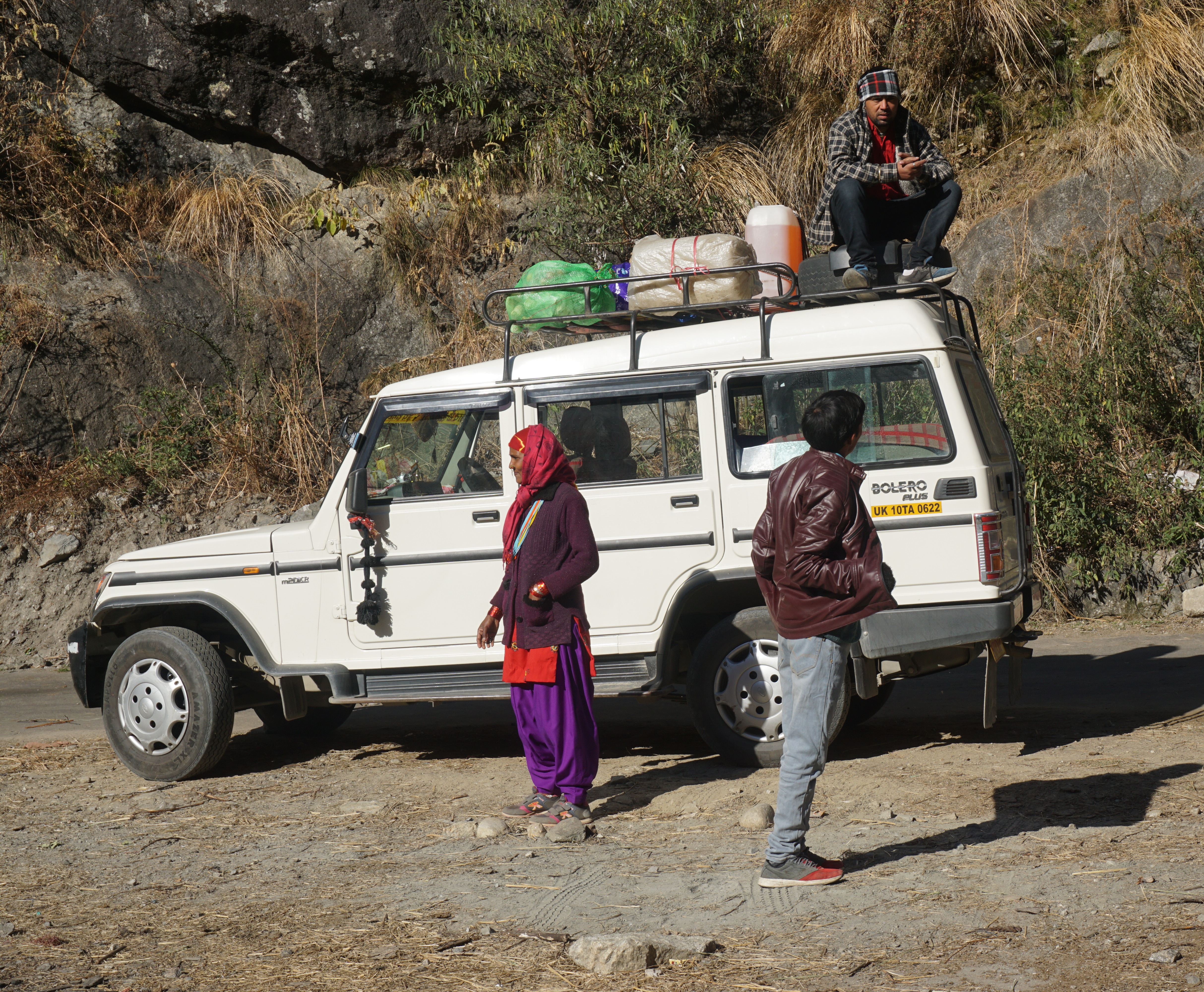 The driver sat on the vehicle as he waited for the Nepali passengers to finish their meet-and-greet. And no, the camera is not tilted; it&rsquo;s the terrain.
