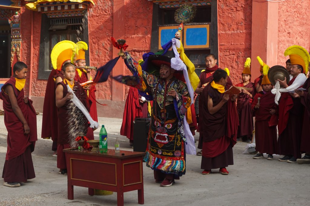 The deity lama throwing a mixture of grains and alcohol after finishing a chant.