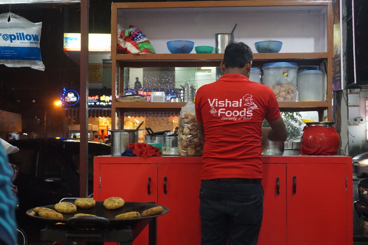 That&rsquo;s the chaat station. You can see out the rain falling on the streets and ghosting the glass panels of the station.