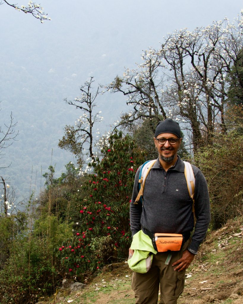 Trilochan Singh—one of the most energetic trekkers—posing in front of the magnolia (white) and rhododendron (red) trees.